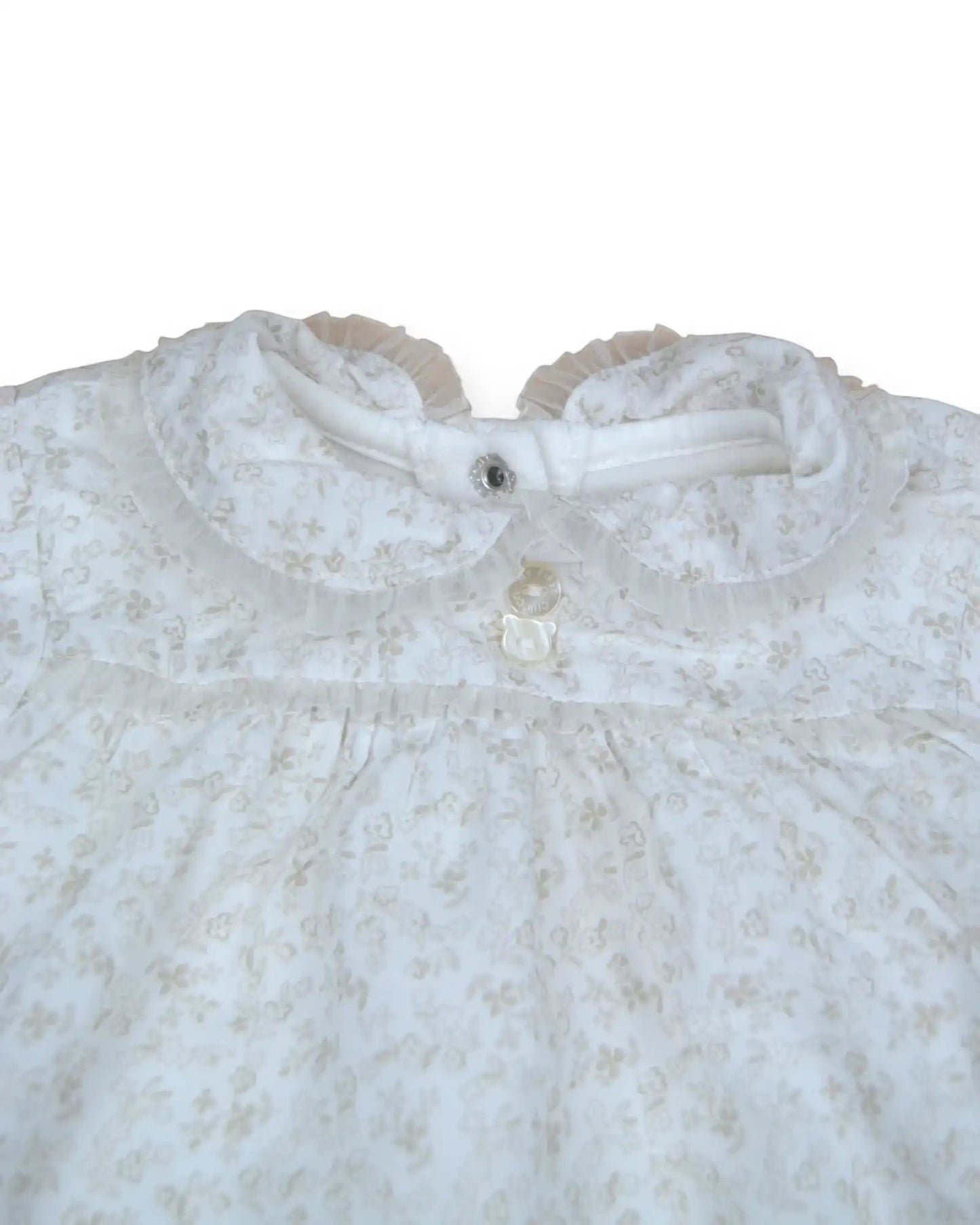 Babygrow polar branco da Chicco  com padrão floral subtil bege, gola com folho e botões em forma de urso.