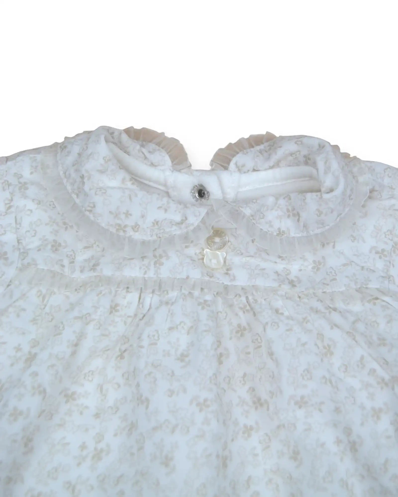 Babygrow polar branco da Chicco  com padrão floral subtil bege, gola com folho e botões em forma de urso.