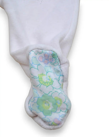 Babygrow rosa de manga comprida da Jacadi com gola em folho e estampado floral em verde e azul. Suave e confortável.