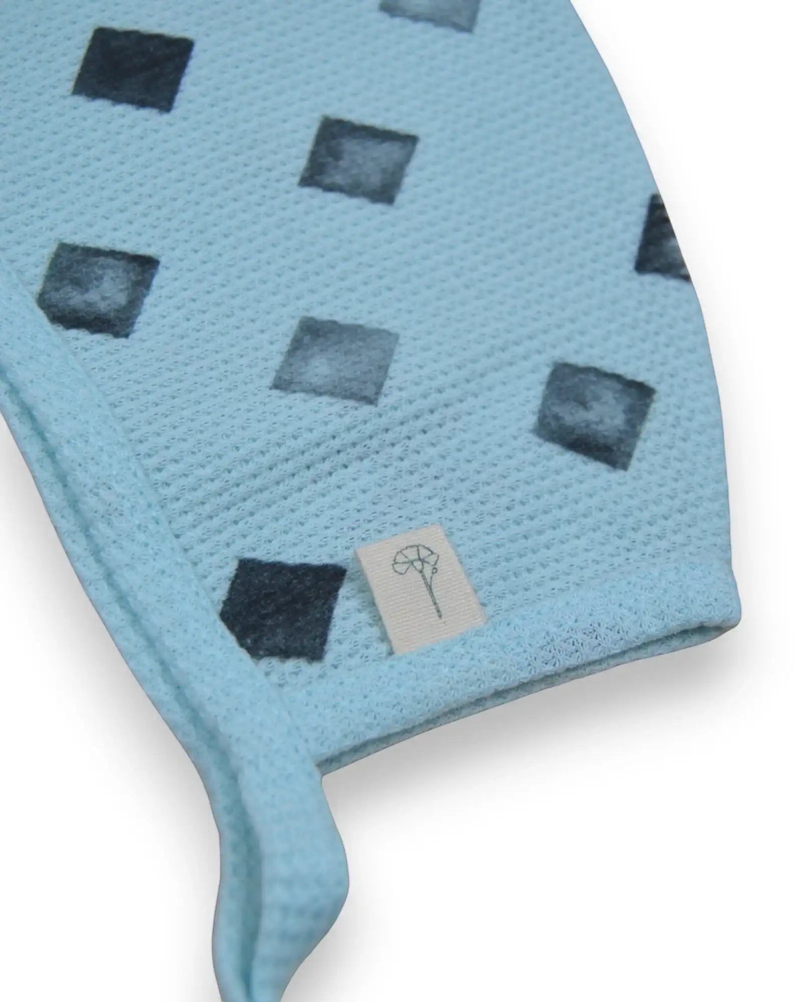 Gorro  azul da Cravinho em algodão texturado com estampado geométrico de losangos e laços para atar