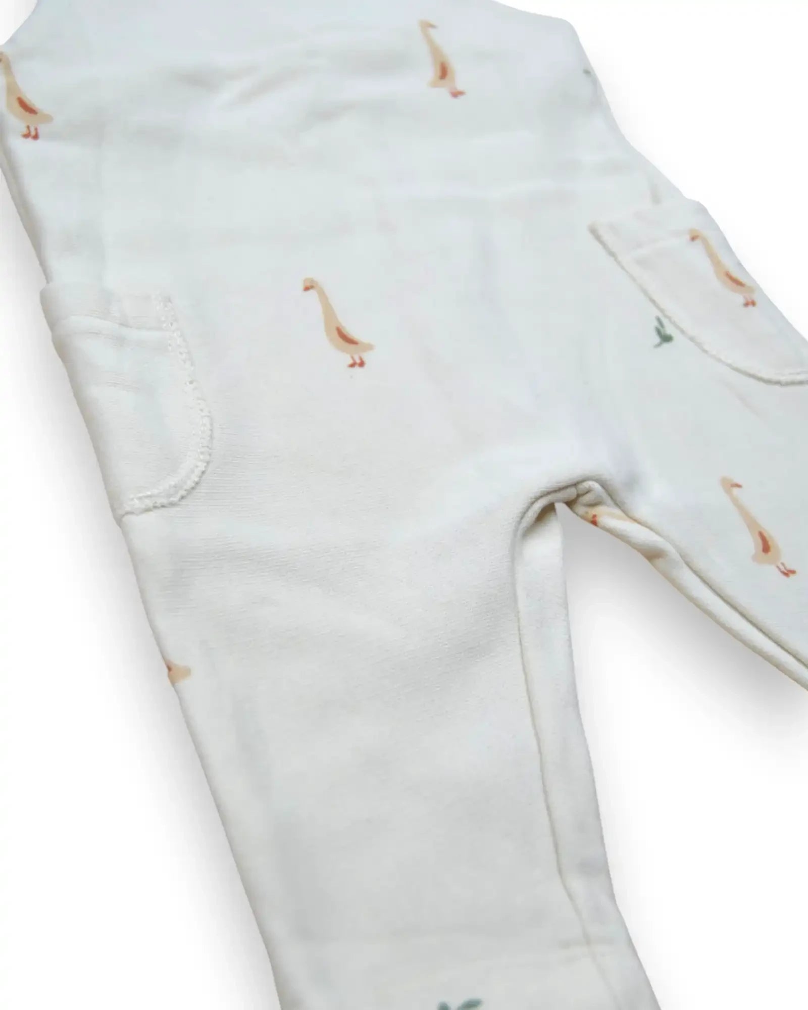 Jardineira de bebé Petit Fox Portugal em algodão branco com padrão delicado de gansos e bolsos laterais funcionais.