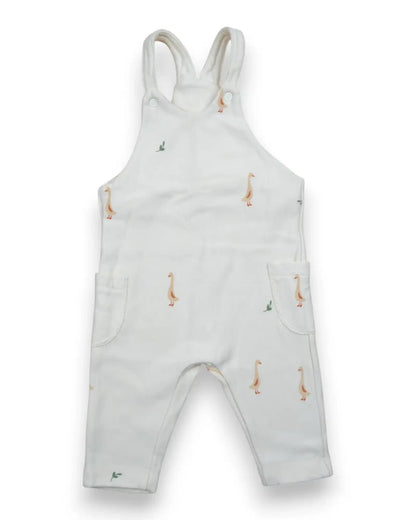 Jardineira de bebé Petit Fox Portugal em algodão branco com padrão de gansos, alças com botões e bolsos laterais.