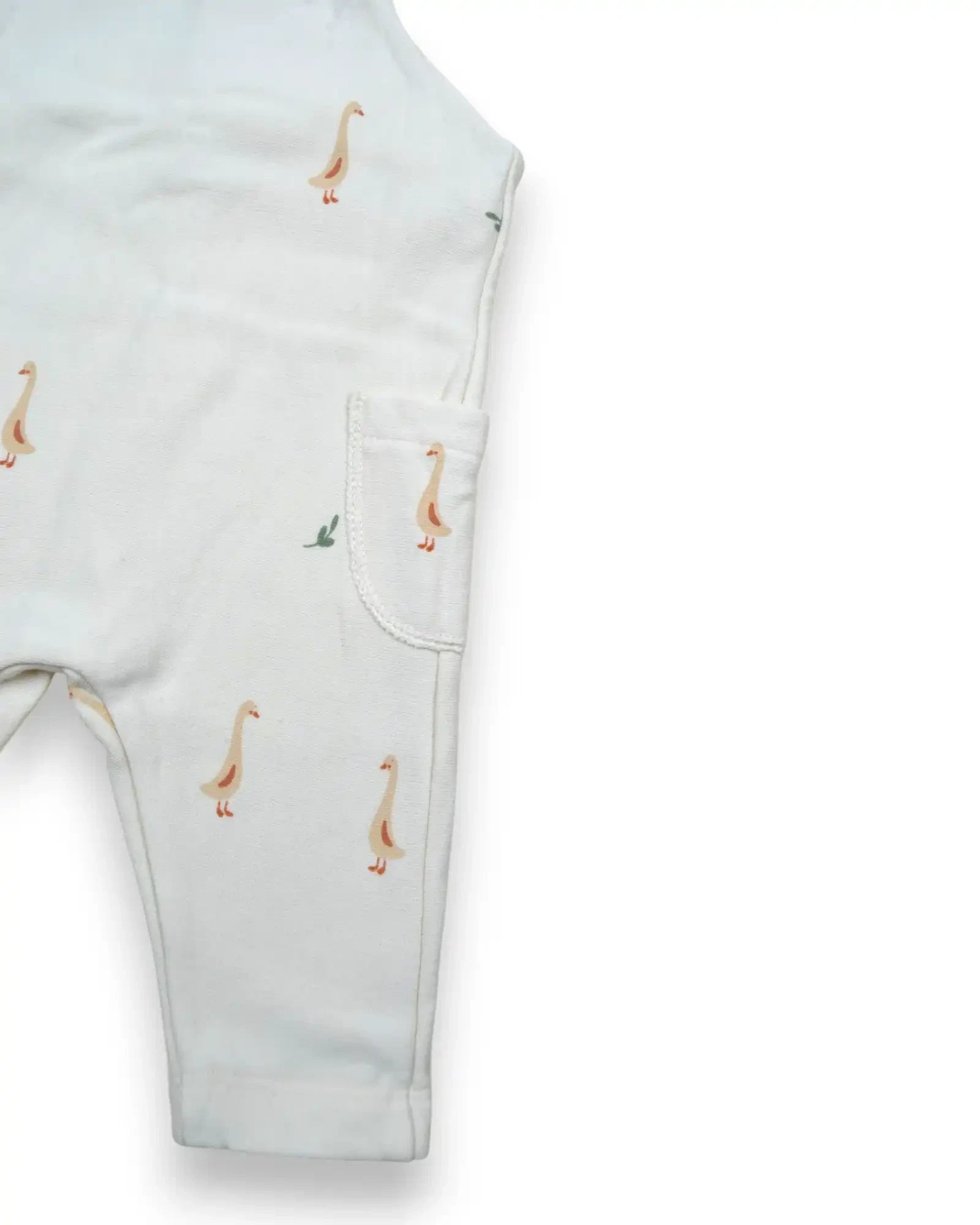 Jardineira de bebé Petit Fox Portugal em algodão branco com padrão de gansos e bolso lateral funcional.