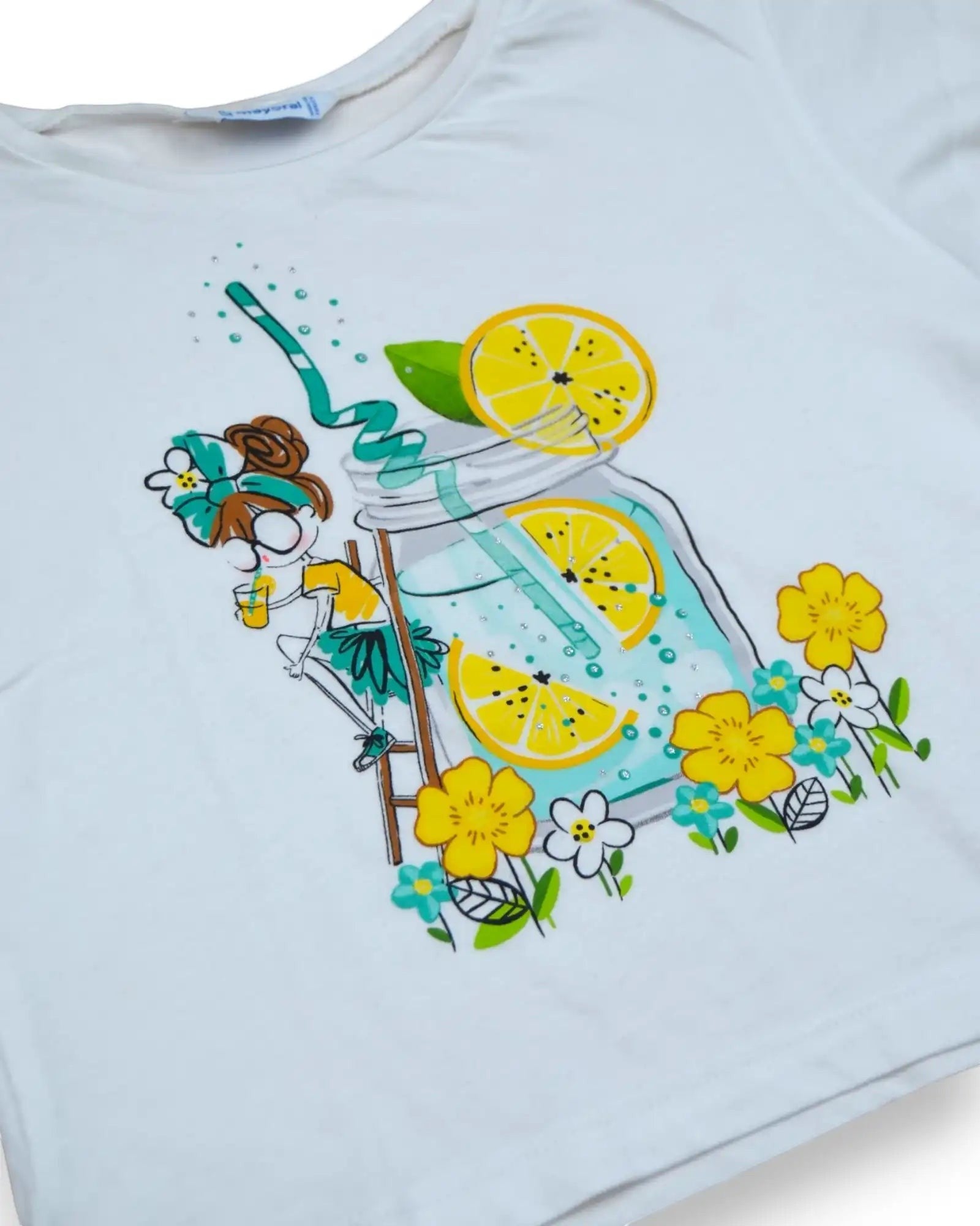 T-shirt branca de manga curta, da Mayoral, estilo cropped, com estampado de limonada e flores. Detalhes em glitter.