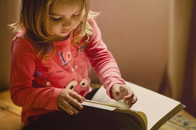 Menina sentada a ler | Como estimular a leitura nas crianças